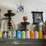Accanto allo scatto, tra lattine colorate, ci sono anche un narghil� e un piccolo Corano...